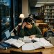 Student studying with books and laptop